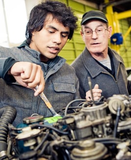 Male student completing practical assignment on an engine